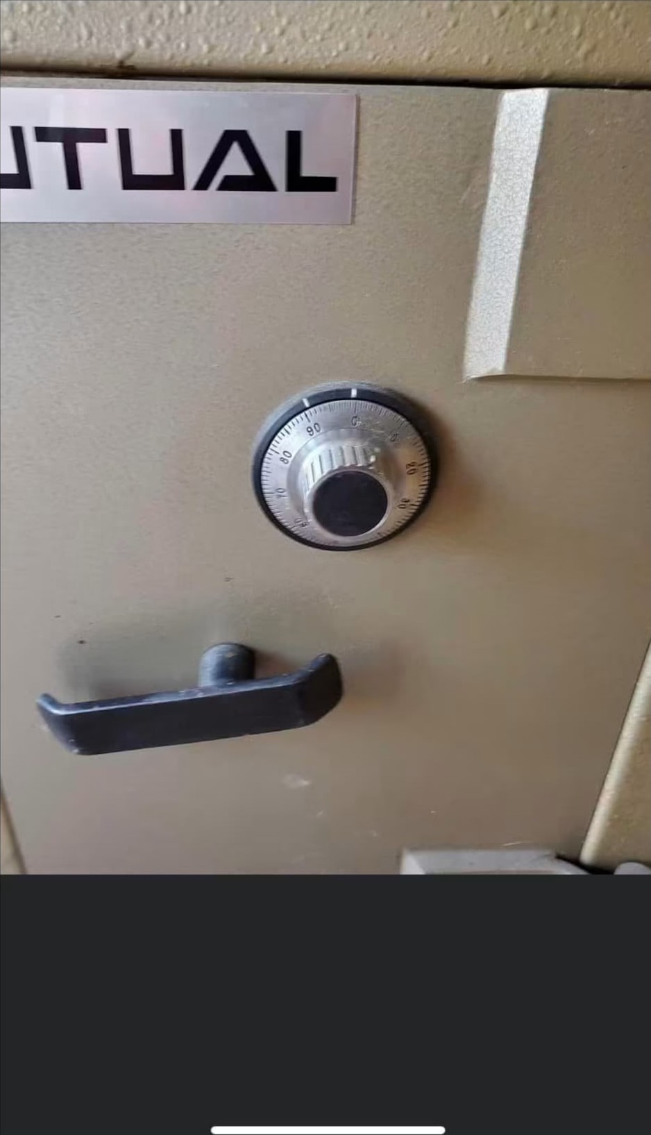 Mechanical combination dial on a safe being manipulated by a London safe engineer
