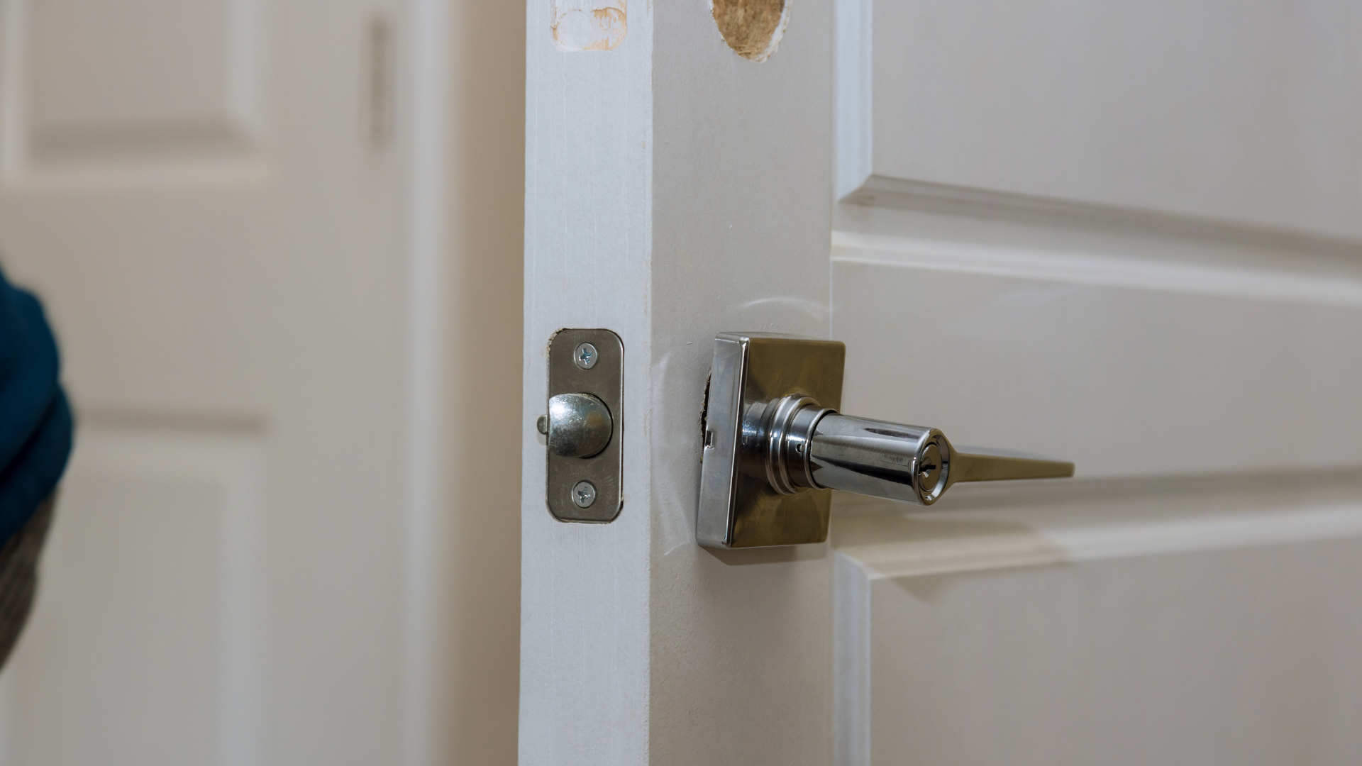 Door latch and cylinder partly removed during a lock repair
